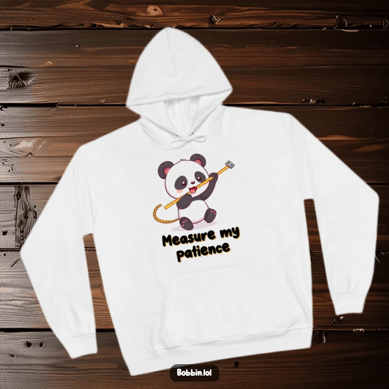 Funny Panda Sewing Hoodie: A playful panda batting at a swinging measuring tape, great for cozy crafting. Perfect funny gift.